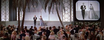 Movie still from “A Star Is Born” (1954), directed by George Cukor – A group of people sitting in front of an audience; Extreme Wide shot, High angle
