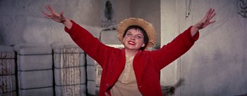 Movie still from “A Star Is Born” (1954), directed by George Cukor – A woman in a straw hat and a red jacket; Medium shot, Low angle