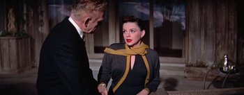 Movie still from “A Star Is Born” (1954), directed by George Cukor – A man and a woman shaking hands in a room; Medium shot, Over the shoulder angle