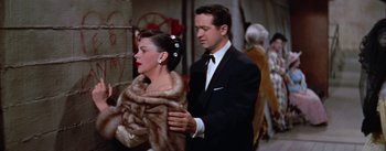 Movie still from “A Star Is Born” (1954), directed by George Cukor – A man and a woman dressed in formal wear; Medium shot, Over the shoulder angle