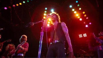 Movie still from “A Star Is Born” (1976), directed by Frank Pierson – A man singing into a microphone on a stage; Wide shot, Low angle