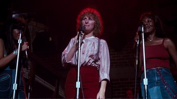 Movie still from “A Star Is Born” (1976), directed by Frank Pierson – A woman standing in front of two microphones on a stage; Medium shot, Low angle