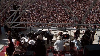 Movie still from “A Star Is Born” (1976), directed by Frank Pierson – A large crowd of people watching a band play; Extreme Wide shot, High angle
