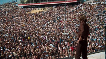 Movie still from “A Star Is Born” (1976), directed by Frank Pierson – A crowd of people sitting in the bleachers watching a concert; Extreme Wide shot, High angle