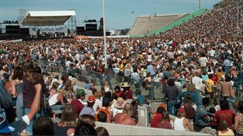Movie still from “A Star Is Born” (1976), directed by Frank Pierson – A crowd of people sitting in bleachers at an event; Extreme Wide shot, High angle