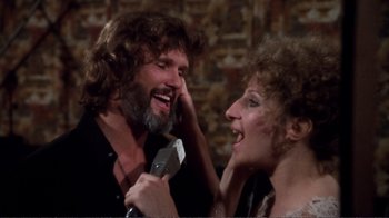 Movie still from “A Star Is Born” (1976), directed by Frank Pierson – A man and a woman singing into microphones; Close Up shot, High angle
