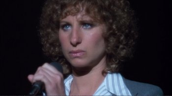 Movie still from “A Star Is Born” (1976), directed by Frank Pierson – A person holding a microphone; Close Up shot, High angle