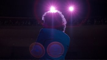 Movie still from “A Star Is Born” (1976), directed by Frank Pierson – A man with a beard is standing in front of a crowd at night; Wide shot, Low angle