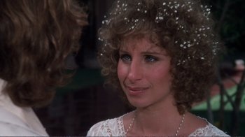 Movie still from “A Star Is Born” (1976), directed by Frank Pierson – A person with curly hair wearing a tiara; Close Up shot, Over the shoulder angle