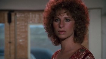 Movie still from “A Star Is Born” (1976), directed by Frank Pierson – A person wearing a red dress; Close Up shot, Over the shoulder angle