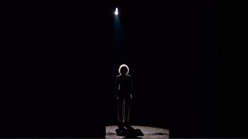 Movie still from “A Star Is Born” (1976), directed by Frank Pierson – A person standing in the dark under a light; Wide shot, Low angle