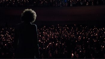 Movie still from “A Star Is Born” (1976), directed by Frank Pierson – A crowd of people are holding candles in the dark; Extreme Wide shot, Low angle