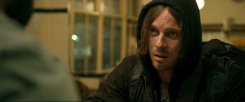 Movie still from “A Street Cat Named Bob” (2016), directed by Roger Spottiswoode – A person wearing a hooded jacket; Close Up shot, Over the shoulder angle