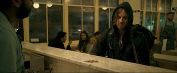 Movie still from “A Street Cat Named Bob” (2016), directed by Roger Spottiswoode – A man standing at the counter of a restaurant; Medium shot, Over the shoulder angle