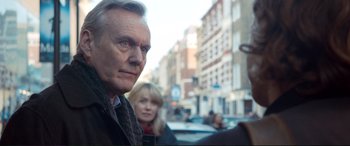 Movie still from “A Street Cat Named Bob” (2016), directed by Roger Spottiswoode – An older man and a younger woman in the street; Close Up shot, Over the shoulder angle