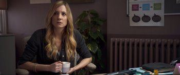 Movie still from “A Street Cat Named Bob” (2016), directed by Roger Spottiswoode – A woman sitting at a table holding a coffee mug; Close Up shot, Over the shoulder angle