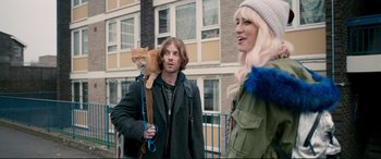 Movie still from “A Street Cat Named Bob” (2016), directed by Roger Spottiswoode – A man and a woman with a cat on their shoulders; Medium shot, Over the shoulder angle