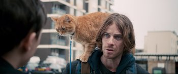 Movie still from “A Street Cat Named Bob” (2016), directed by Roger Spottiswoode – A man with a cat on his shoulder; Close Up shot, Low angle