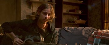 Movie still from “A Street Cat Named Bob” (2016), directed by Roger Spottiswoode – A man sitting in front of an acoustic guitar; Close Up shot, Over the shoulder angle