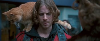 Movie still from “A Street Cat Named Bob” (2016), directed by Roger Spottiswoode – A person holding a teddy bear; Close Up shot, Over the shoulder angle