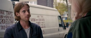 Movie still from “A Street Cat Named Bob” (2016), directed by Roger Spottiswoode – A man standing in front of a white van; Close Up shot, Over the shoulder angle