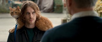 Movie still from “A Street Cat Named Bob” (2016), directed by Roger Spottiswoode – A man holding a teddy bear over his shoulder; Close Up shot, Over the shoulder angle