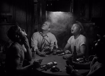 Movie still from “A Streetcar Named Desire” (1951), directed by Elia Kazan – A group of people sitting around a table smoking and drinking; Medium shot, Low angle