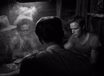 Movie still from “A Streetcar Named Desire” (1951), directed by Elia Kazan – A man sitting in front of two other men in front of a mirror; Medium shot, Over the shoulder angle