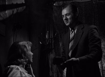 Movie still from “A Streetcar Named Desire” (1951), directed by Elia Kazan – A man and a woman are talking in a dark room; Medium shot, Low angle