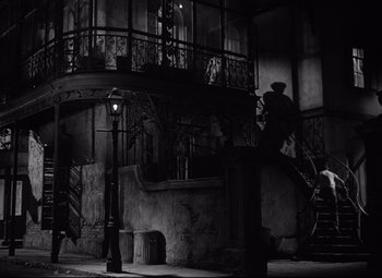 Movie still from “A Streetcar Named Desire” (1951), directed by Elia Kazan – A black - and - white photo of a staircase in a building; Wide shot, Low angle