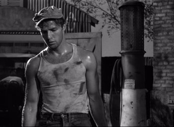 Movie still from “A Streetcar Named Desire” (1951), directed by Elia Kazan – Black and white photograph of a man in a tank top; Medium shot, Low angle