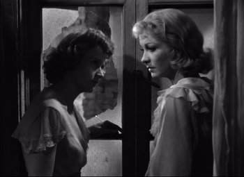 Movie still from “A Streetcar Named Desire” (1951), directed by Elia Kazan – Two women standing next to each other in front of a window; Medium shot, Low angle