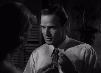 Movie still from “A Streetcar Named Desire” (1951), directed by Elia Kazan – A black and white photo of a man adjusting his tie; Close Up shot, Over the shoulder angle