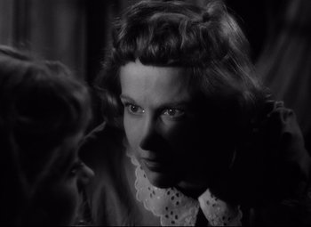 Movie still from “A Streetcar Named Desire” (1951), directed by Elia Kazan – A black - and - white photo of a woman in a white collar; Close Up shot, Over the shoulder angle