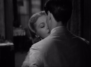 Movie still from “A Streetcar Named Desire” (1951), directed by Elia Kazan – A man and a woman are kissing in a room; Close Up shot, Over the shoulder angle