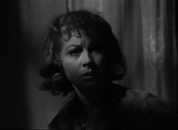 Movie still from “A Streetcar Named Desire” (1951), directed by Elia Kazan – A black - and - white photo of a woman in front of a curtain; Close Up shot, Low angle