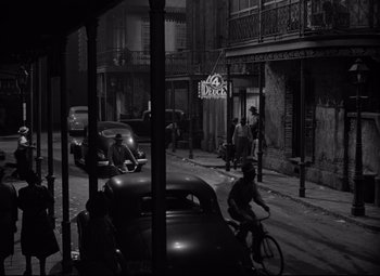 Movie still from “A Streetcar Named Desire” (1951), directed by Elia Kazan – A black and white photo of a city street with cars parked on the side of the street; Extreme Wide shot, High angle