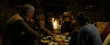 A group of people sitting around a table with plates of food