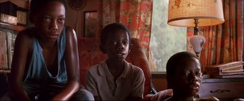 Movie still from “A Time to Kill” (1996), directed by Joel Schumacher – A young boy sitting in a chair in front of a window; Close Up shot, Low angle