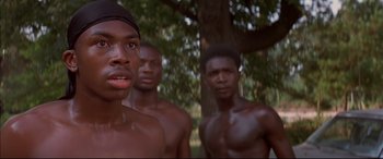 Movie still from “A Time to Kill” (1996), directed by Joel Schumacher – A group of men standing next to each other in front of a tree; Close Up shot, Over the shoulder angle