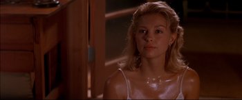 Movie still from “A Time to Kill” (1996), directed by Joel Schumacher – A young woman in a white tank top looking at the camera; Close Up shot, Low angle