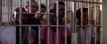 Movie still from “A Time to Kill” (1996), directed by Joel Schumacher – A group of men standing next to each other in front of a jail cell; Medium shot, High angle