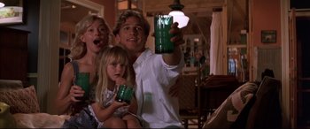 Movie still from “A Time to Kill” (1996), directed by Joel Schumacher – A man and a woman and a little girl are holding up a green cup; Medium shot, Low angle