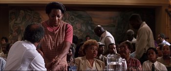 Movie still from “A Time to Kill” (1996), directed by Joel Schumacher – A group of people sitting around a table; Medium shot, Low angle