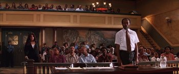 Movie still from “A Time to Kill” (1996), directed by Joel Schumacher – A group of people sitting in front of an audience in a courtroom; Wide shot, Low angle