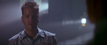 Movie still from “A Time to Kill” (1996), directed by Joel Schumacher – A man with spiky red hair is standing in a dark room; Close Up shot, Low angle