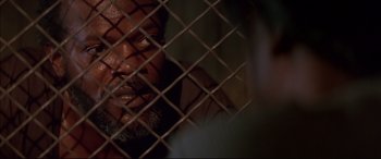 Movie still from “A Time to Kill” (1996), directed by Joel Schumacher – A person behind a chain link fence; Close Up shot, Over the shoulder angle