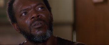 Movie still from “A Time to Kill” (1996), directed by Joel Schumacher – A person with a beard looking at the camera; Close Up shot, Low angle