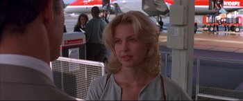 Movie still from “A Time to Kill” (1996), directed by Joel Schumacher – A beautiful woman with blonde hair standing in front of an airplane; Close Up shot, Over the shoulder angle
