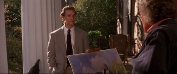 Movie still from “A Time to Kill” (1996), directed by Joel Schumacher – A man standing in front of an easel holding a painting; Medium shot, Low angle